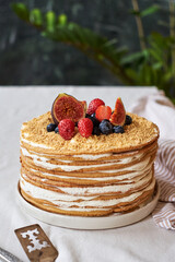 Honey cake decorated with blueberries, figs and strawberries. Side view. Layer cake.