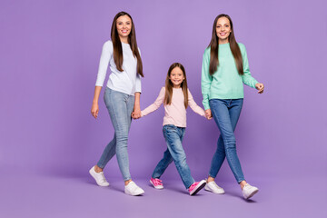 Full length body size profile side view of three lovely cheery girls going holding hands isolated over purple violet color background
