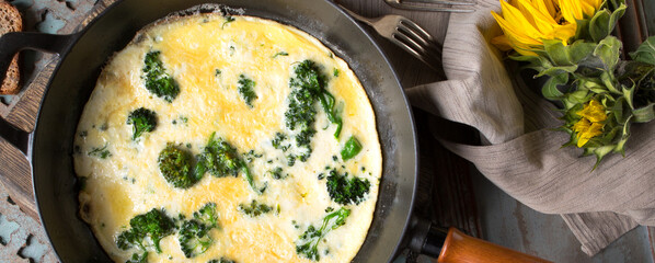 frying pan with omelette with broccoli on the table