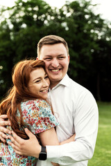 couple in love hugs in nature at sunset. romantic setting. husband with wife in the park. walk of lovers. strong hugs of a young family.