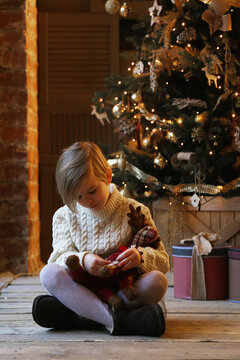 The child hugs a soft toy while sitting in warm clothes.
