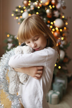Close-up of a girl hugging a soft toy.