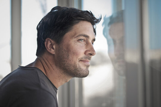 portrait of man looking out the window