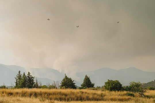 Emergency, wildfire. Seaplanes flying over a forest fire to extinguish