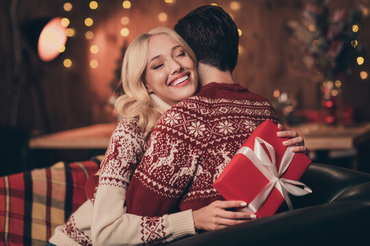 Photo of excited adorable wife husband dressed print pullovers getting christmas gift smiling indoors room home house