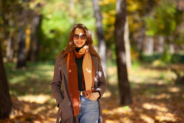 Beautiful young woman walks in the autumn forest
