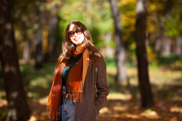 Portrait of a beautiful young woman in sunglasses in the autumn forest