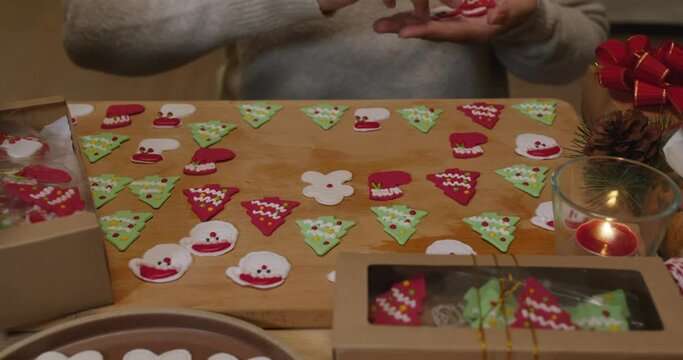 Asia woman enjoy fun make craft gift for night party tasty snack cooking recipe on table in good warm relax time. Cute smile gingerman mold shape bakery icing sugar glaze with red green white color.