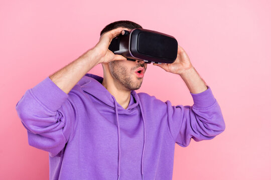 Photo of young man amazed shocked surprised simulation vr isolated over pink color background