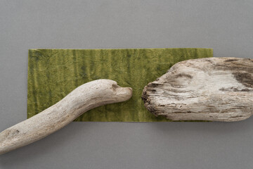 two pieces of driftwood arranged on a paper background