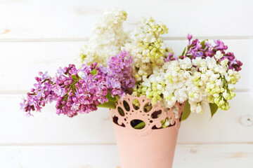 Bouquet of Purple and White Lilac  in a Pink Vintage Vase on a  Wooden Background 