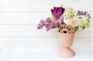 Bouquet of Purple and White Lilac  in Pink Vase with Copy Space on a  White Wooden Background 