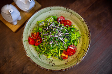 Healthy vegetable salad of fresh tomato, cucumber, onion, spinach, lettuce and sesame on plate. Diet menu.