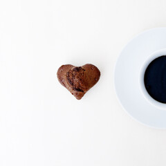 Chocolate cookie with coffee on the table in the style of minimalism. Shape of heart. Minimal style. Minimalist Fashion photography