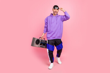 Full body photo of young cool guy ego party hold boombox music lover isolated over pink color...