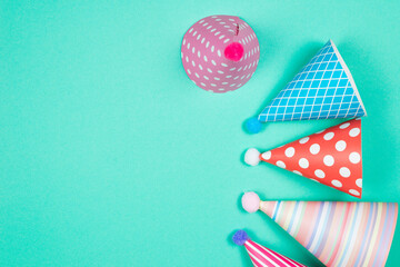 Obraz premium Colorful birthday caps on a blue background. Top view.