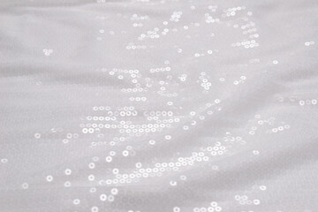 White sequin background. White shiny sequin fabric.