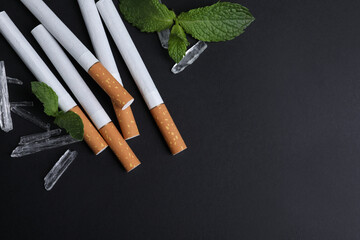 Cigarettes, menthol crystals and mint on black background, flat lay. Space for text