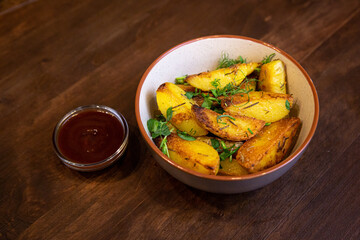 baked fried potatoes with herbs and red sauce