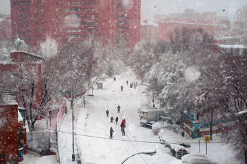 People walking under the snow in the city. Walking during the Filomena snow storm, Madrid, Spain.