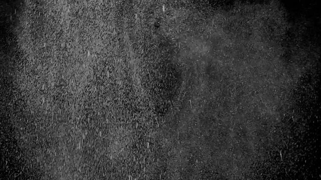 Flow of liquid drops flies swirling and falling down on black