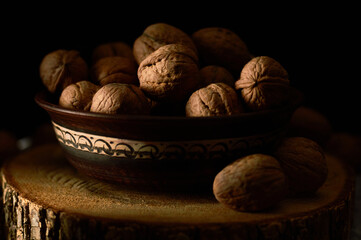 Грецкие орехи на темном винтажном столе, ядра грецких орехов в деревянной миске. Грецкий орех здоровое питание
