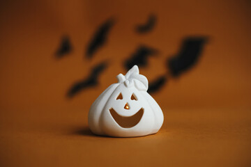 Happy Halloween. Jack o lantern pumpkin decoration on dark orange background with flying black...