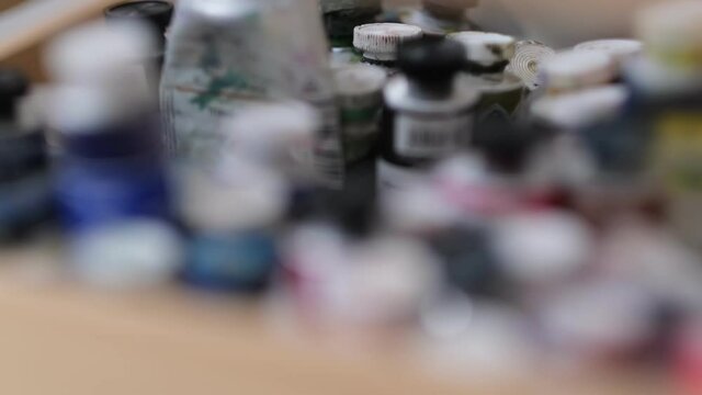 Artist workplace. Neatly organized home art studio. Oil paints are decomposed in a wooden box. Blur focus