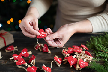 Woman making an advent calendar for her child, preparation for Christmas, holiday DIY crafting.