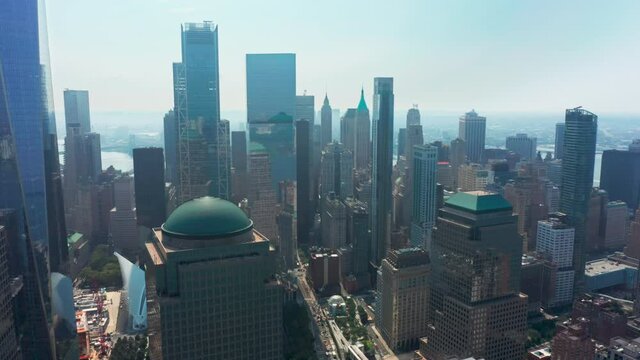 Drone flying backwards from business offices on lower Manhattan, World Trade center at ground zero memorial. Panoramic view on Wall street business district with banks buildings in New York city