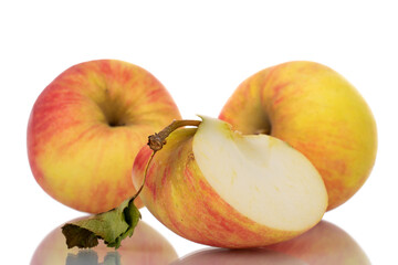 One sweet organic apple slice in focus and two whole apples in the background, close-up, isolated on white.
