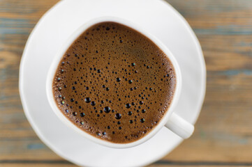 Top view of coffee cup on a wood background with copy space.