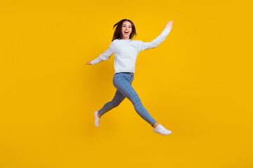 Fototapeta na wymiar Full length photo of happy young woman jump up walk enjoy good mood isolated on yellow color background