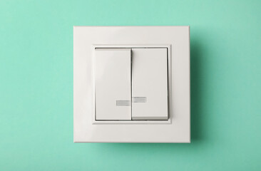 Modern plastic light switch on turquoise background