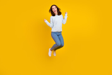 Fototapeta na wymiar Full length photo of cheerful young woman jump up winner good mood enjoy isolated on yellow color background