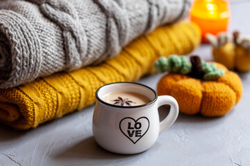 White cup of hot cocoa with spicy on grey table, close-up