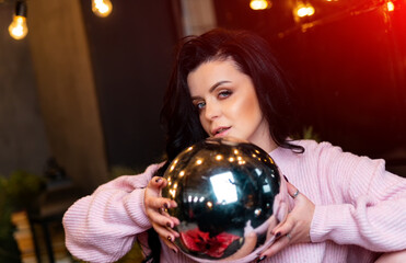 Christmas, decorations, holidays and people concept. Close up of woman holding Christmas ball at New tree background