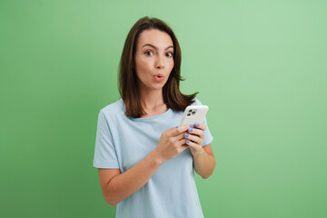 Young woman expressing surprise while using cellphone