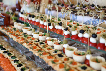 Festive buffet table. Sandwiches with black and red caviar. Tomatoes with cheese and olives.