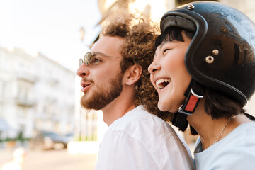 Happy young multiethnic couple on scooter