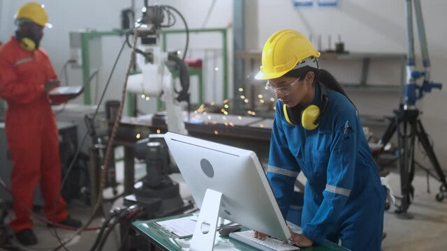 specialist technical engineer hand input programing code data computing to manage movement work flow of robotarm welding machinery in workshop modern factory smart industrial manufacture concept