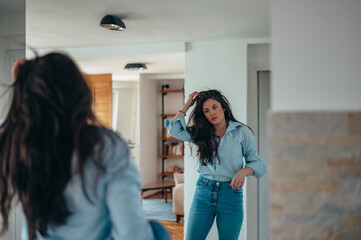 Attractive young businesswoman getting dressed for work at home