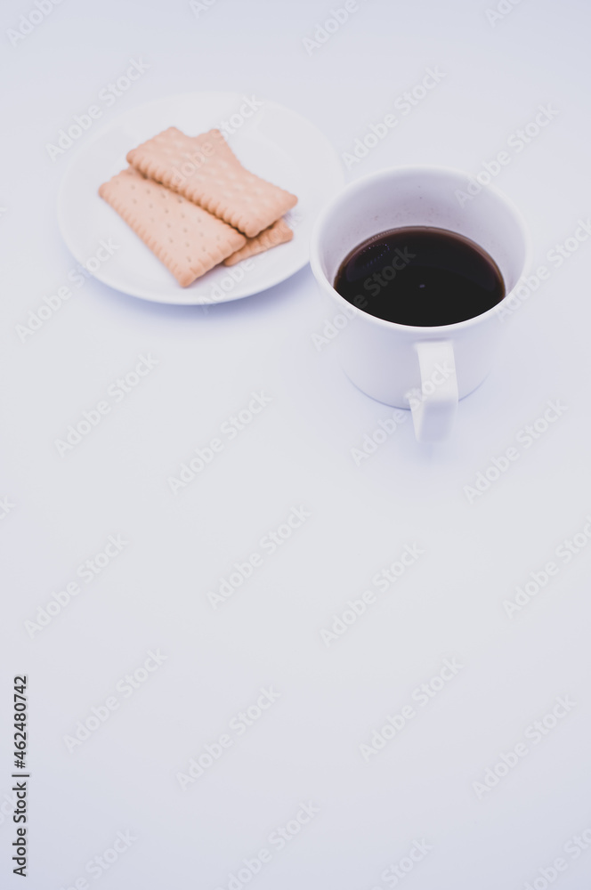 Sticker cup of black coffee and light crisp cookies in a white plate