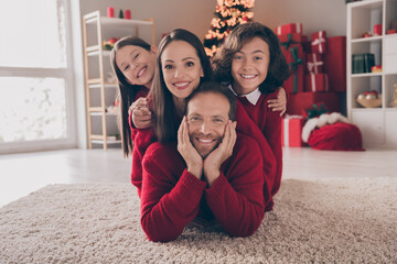 Photo of lovely full family lie down on carpet hug wear red jumpers new year at house