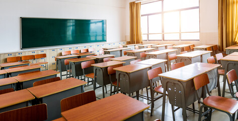 Empty classroom with desks, chairs and chalkboard