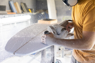 Surfboard Modeling Workshop - Man shaping a surfboard with a sander