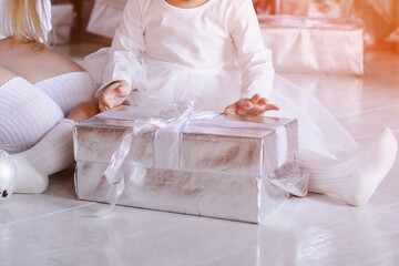 Child and moms hands holding gift box. Christmas, new year, birthday concept.