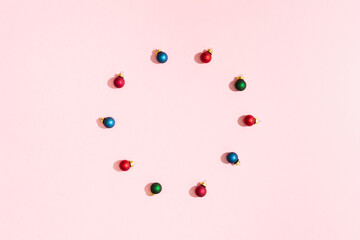 Circle of Christmas colorful balls on pink pastel paper backgrond and copy space