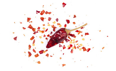 Crushed red cayenne pepper and one dried chili paprika isolated on white background, top view