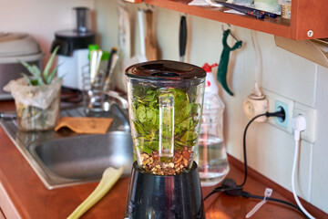 Fototapeta na wymiar Blender with nuts and spinach. Ready for the pesto to be made. 